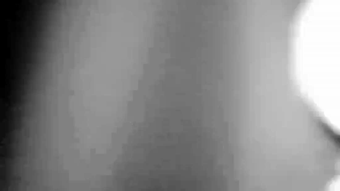 A body turning, wall behind